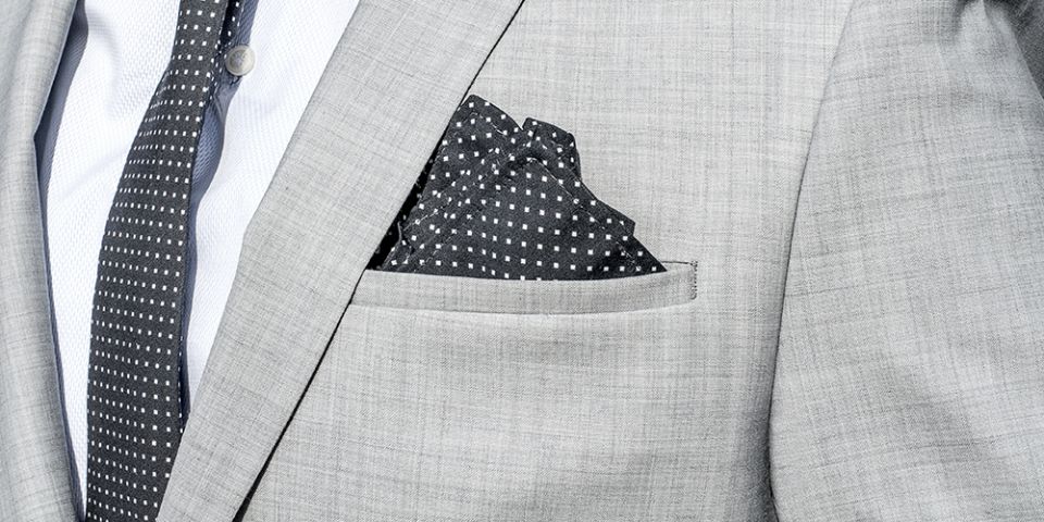 Muž v šedom saku s vreckovkou do saka Coloo square a kravatou Coloo Tie