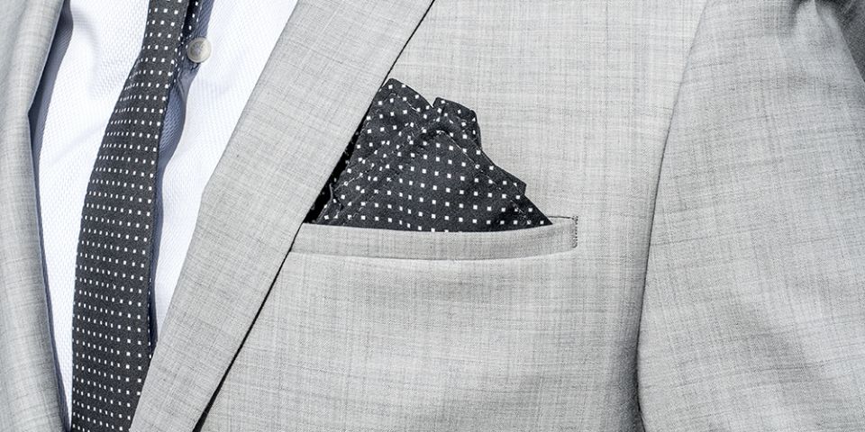 Muž v šedom saku s vreckovkou do saka Coloo square a kravatou Coloo Tie Muž v šedom saku s vreckovkou do saka Coloo square a kravatou Coloo Tie
