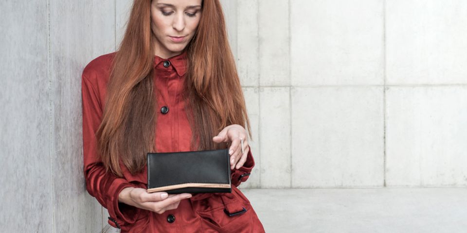 BeWooden - Žena s ryšavými vlasmi v oranžovom kabátiku drží koženú peňaženku Api Woman Wallet