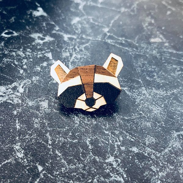 Drevená brošňa Raccoon Brooch na stole